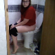 A brunette girl with glasses records herself taking a shit while sitting on a very tall toilet. Her feet barely touch the floor. She reads while going and then wipes her ass when finished. About 4.5 minutes.